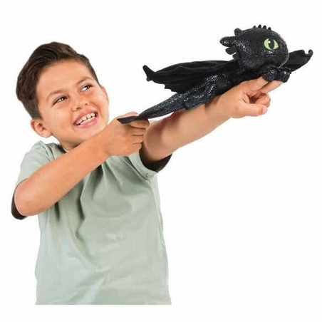 Niño jugando con peluche dragón volador juguete