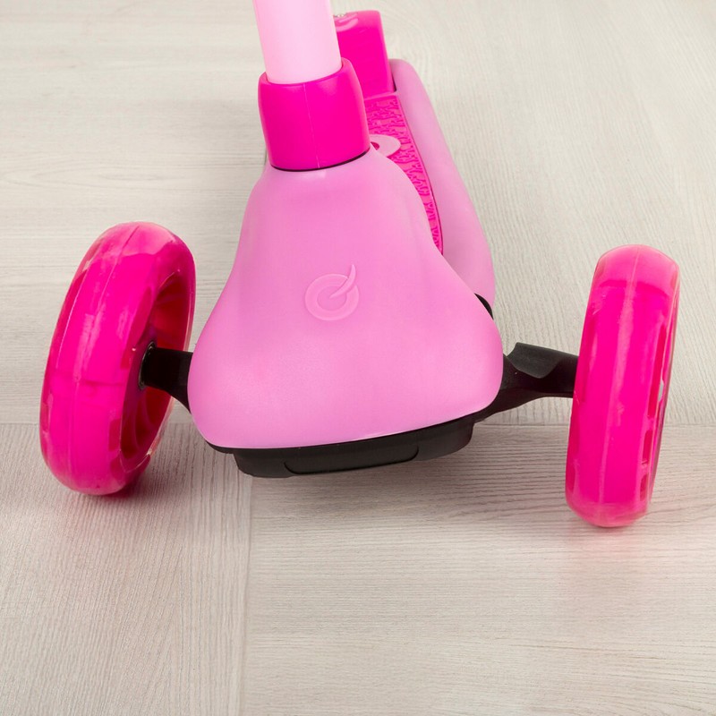 Niño feliz montando patinete 4 en 1 rosa con asiento y manillar de empuje