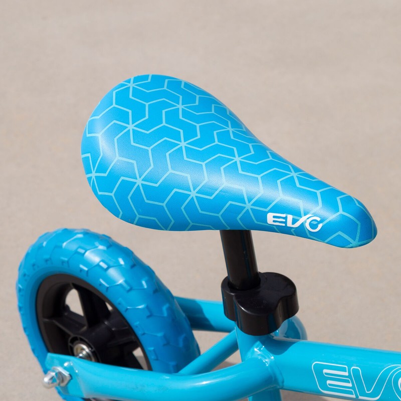 Niño feliz montando bicicleta de equilibrio para niños azul
