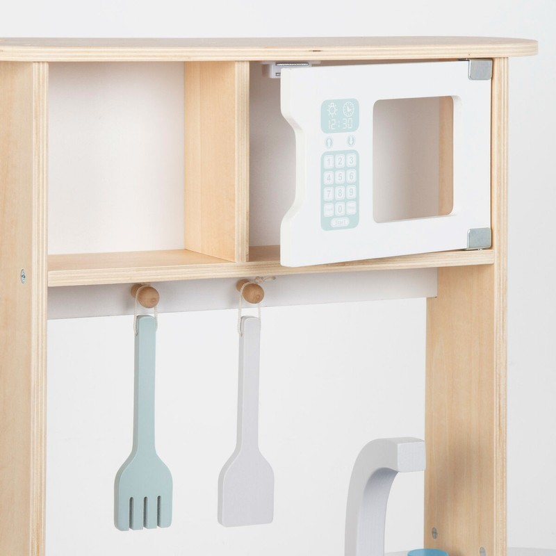 Niña jugando con cocinita infantil de madera WOOMAX