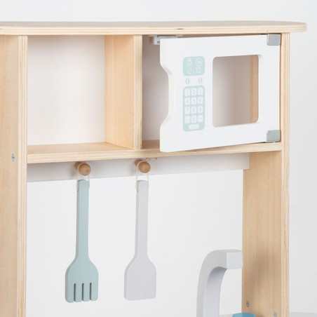 Niña jugando con cocinita infantil de madera WOOMAX