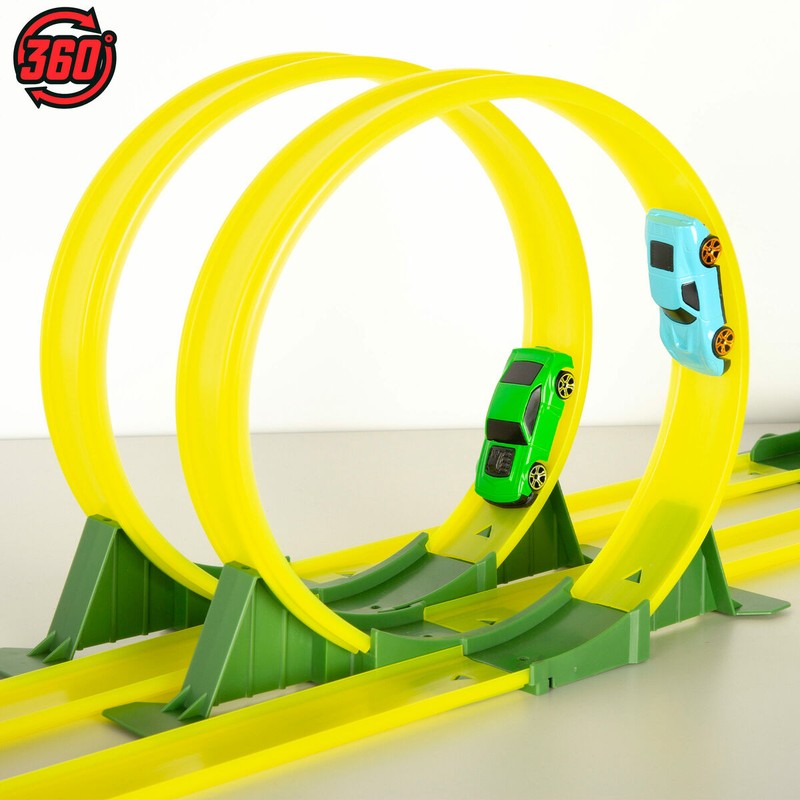 Niño jugando con pista de coches y dinosaurios
