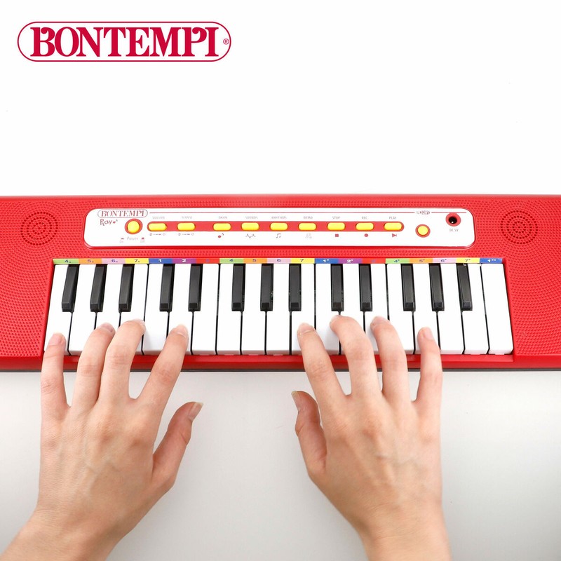 Niños tocando un teclado electrónico para niños, fomentando la creatividad grupal.