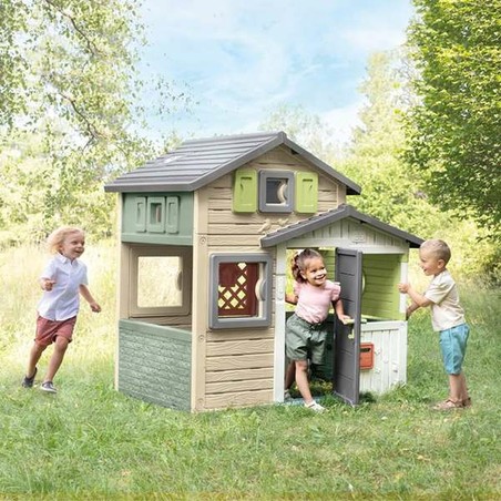 Familia disfrutando de la casita de juguete exterior Smoby en un día soleado