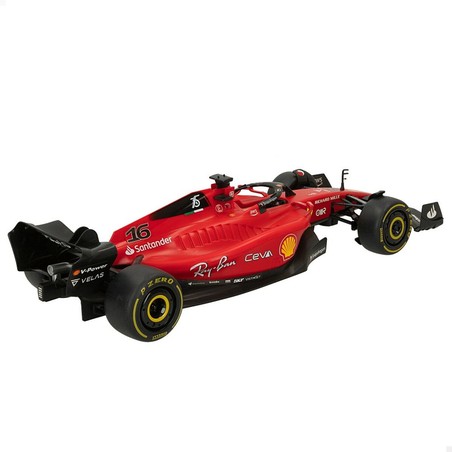 Niño jugando con coche teledirigido Ferrari en pista de coches imaginaria