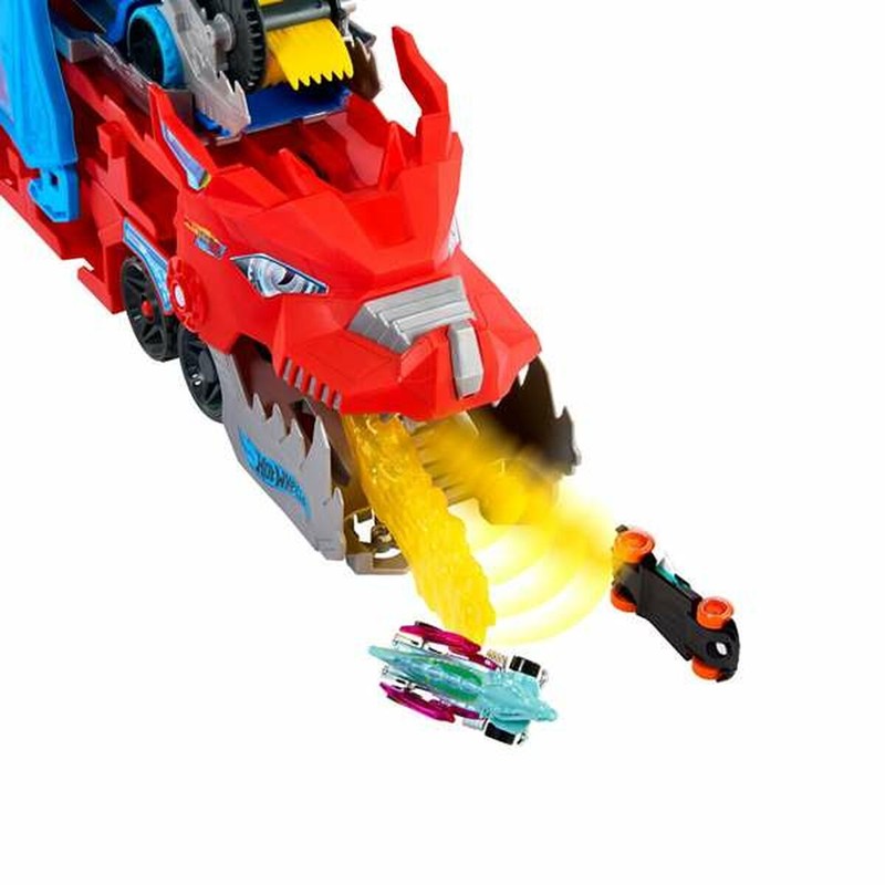 Escena de juego con el Transportador Dragón Hot Wheels y vehículos adicionales.