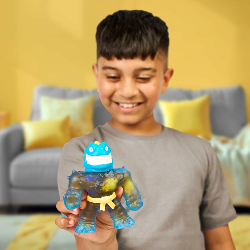 Niño jugando y estirando una figura acción Goo Jit Zu